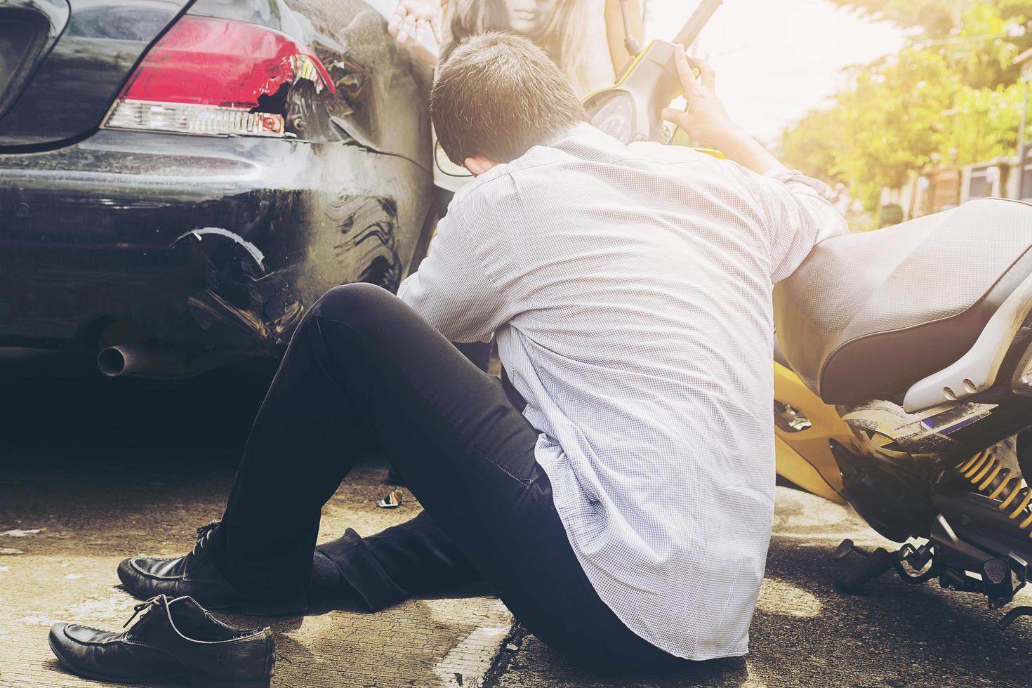 Accident of motorcycle and car with injured man who ride motorcycle photo