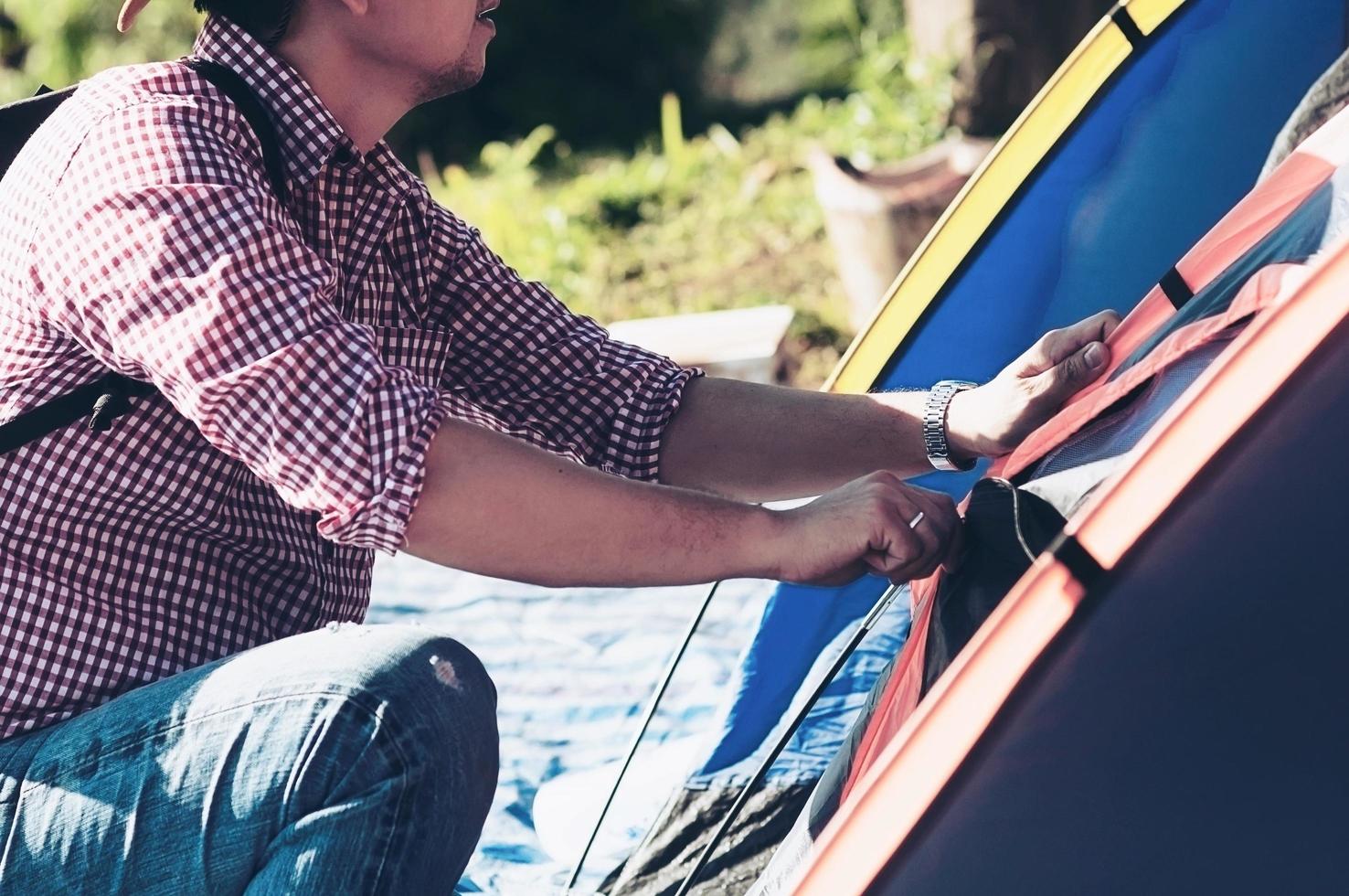 young man open or close tent door in morning sun light time during his camping in local high land area chiang mai thailand - people camping concept photo