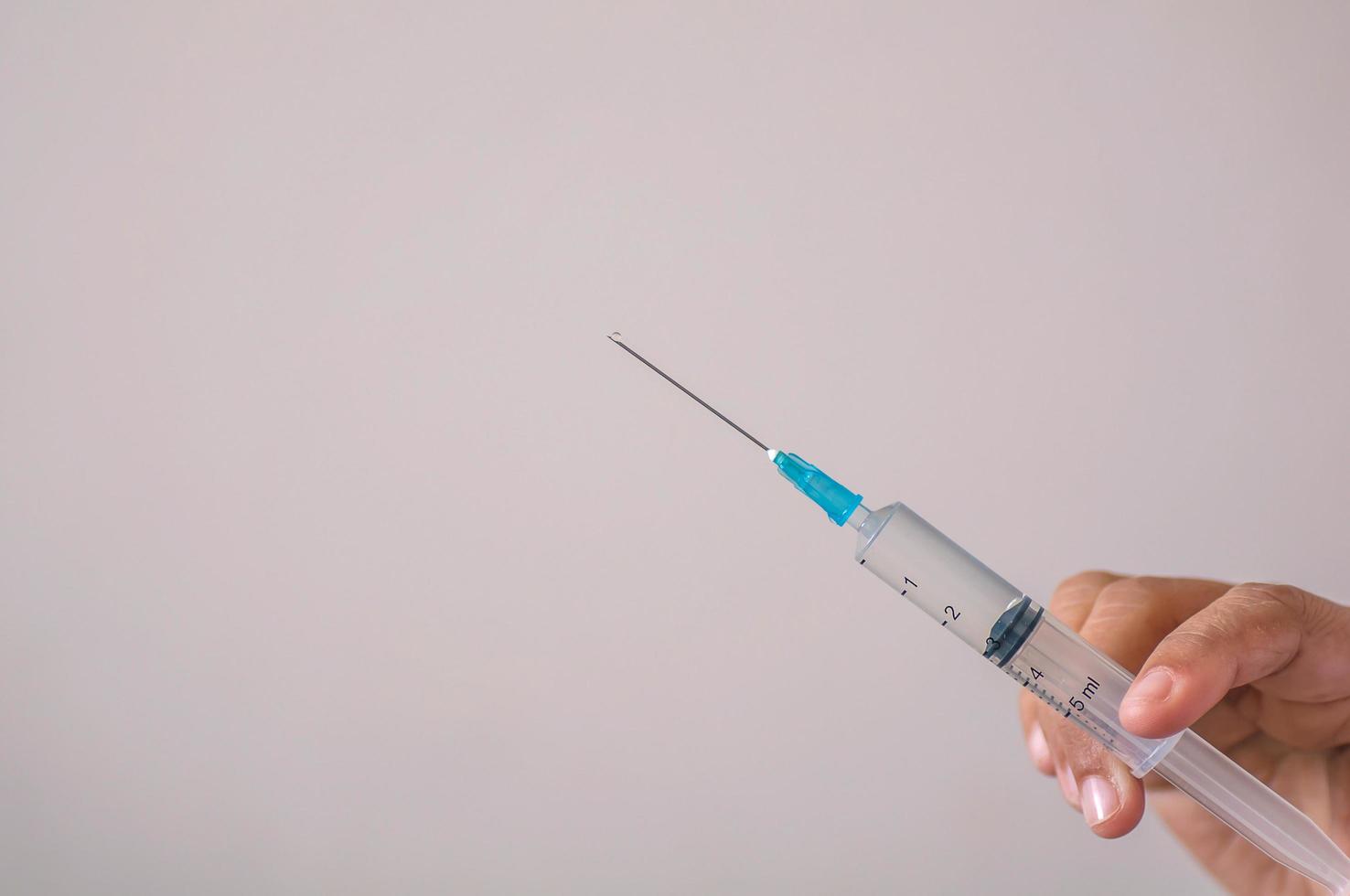 médico sosteniendo la jeringa en la mano lista para inyectar para uso en segundo plano foto