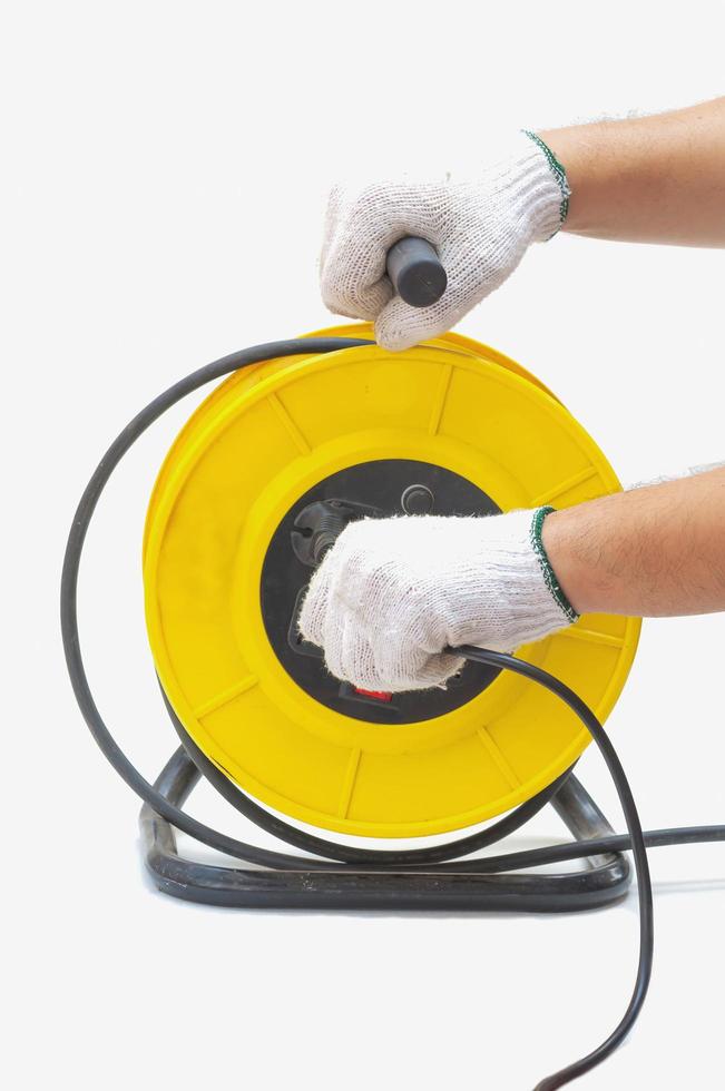 Electric cord reel and hand with glove isolated over white photo