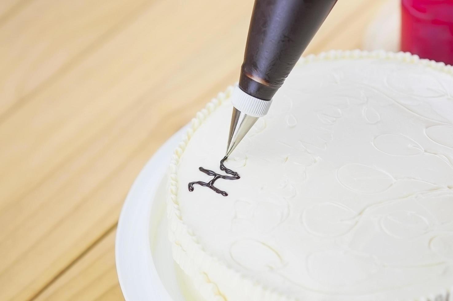Cake decorating using piping tip for writing a word photo
