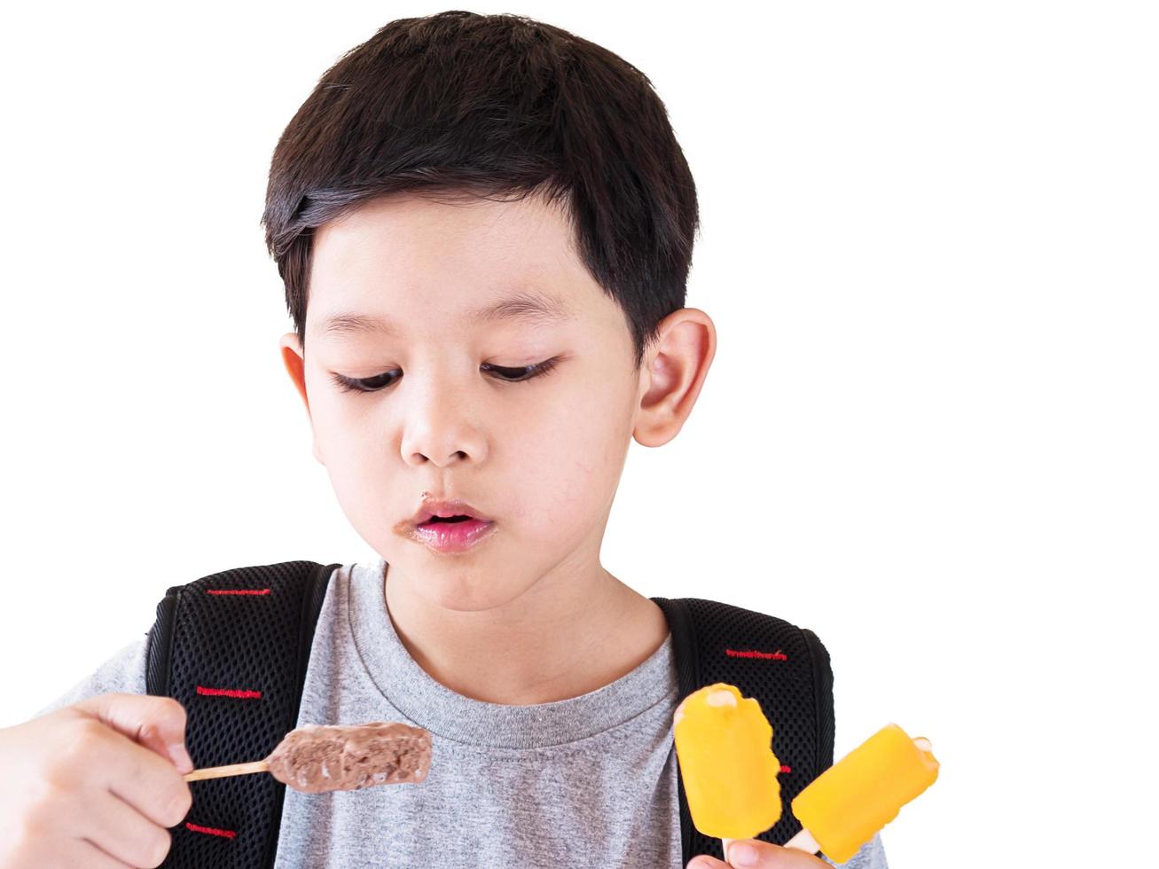 Boy eating ice cream isolated over white background photo