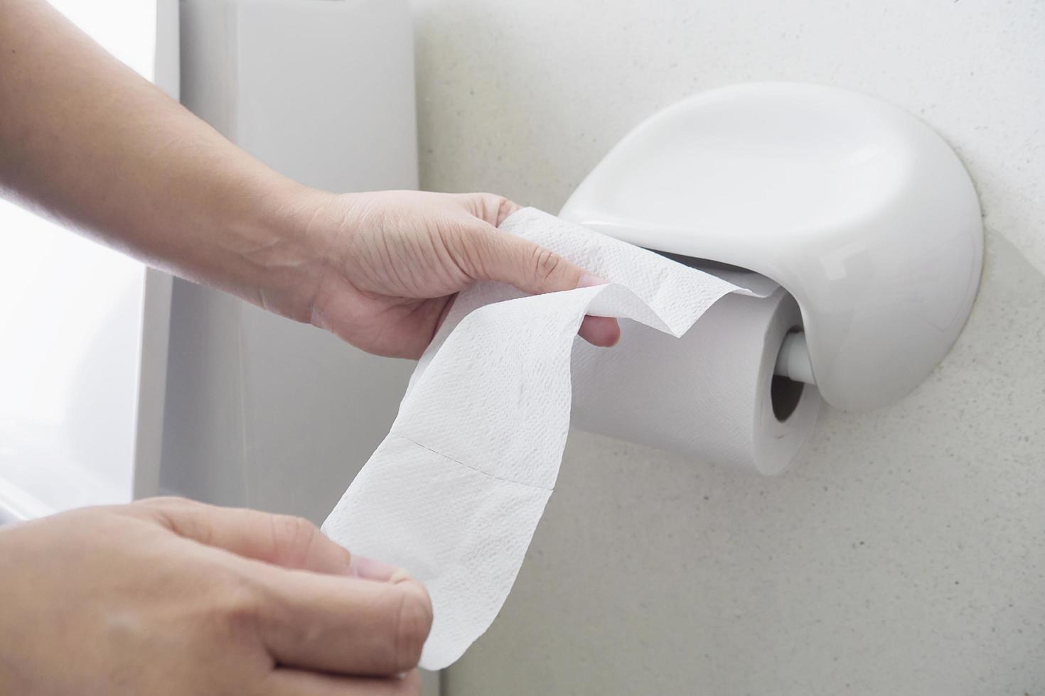 Lady pulling tissue in toilet photo