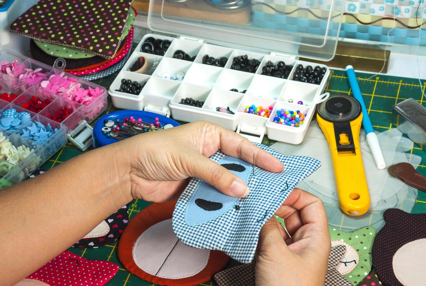 A woman is doing needlework with other embroidery equipment on a table photo