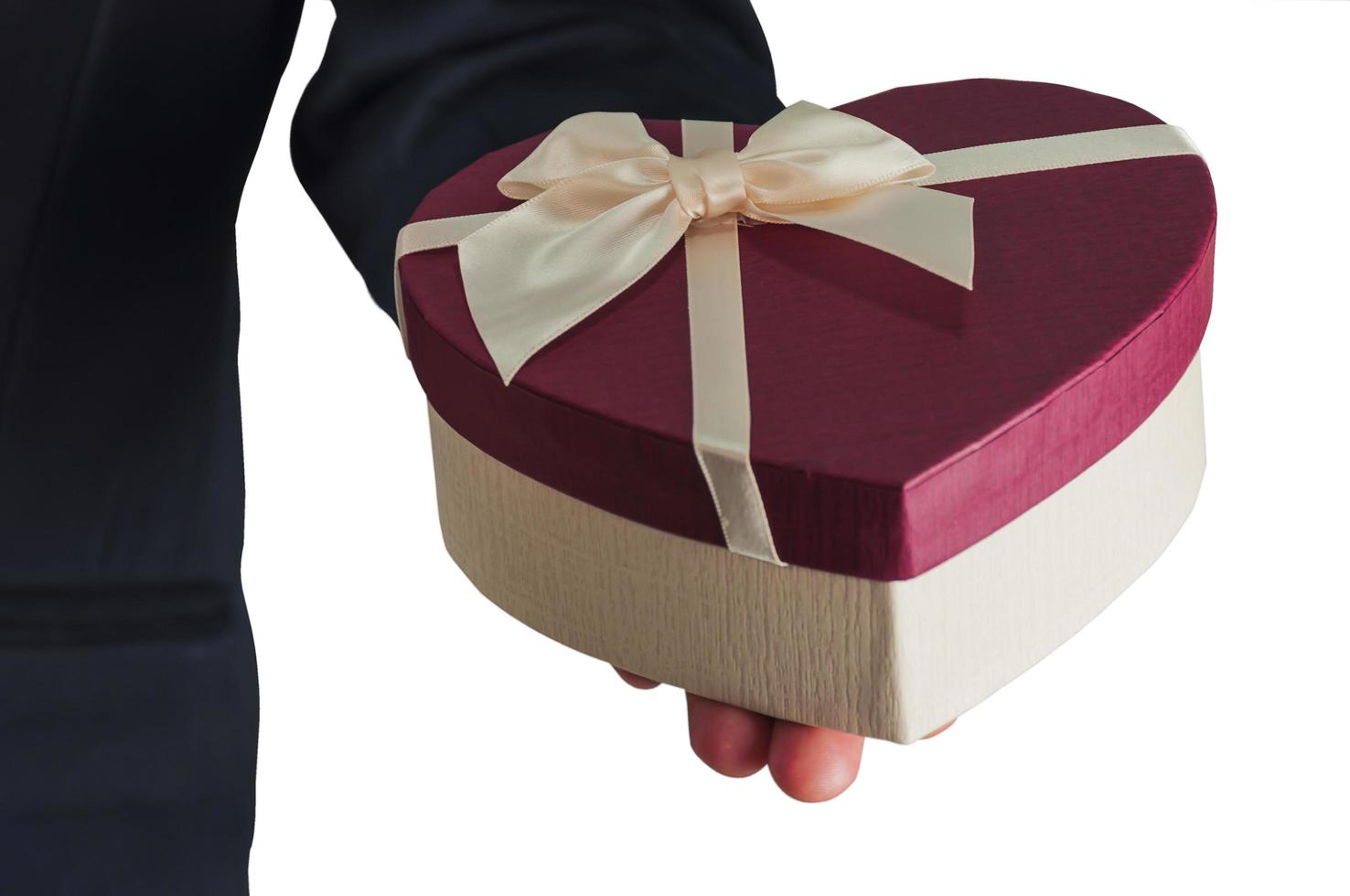 Businessman is giving heart box gift isolated over white photo