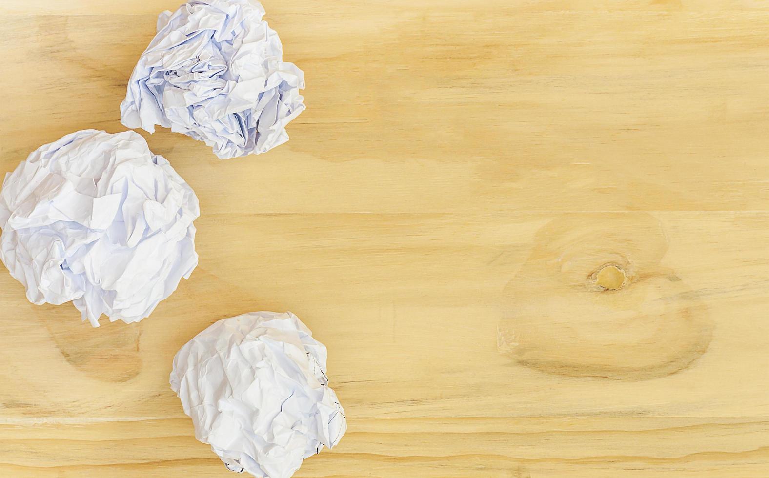 Crumpled paper balls over wooden surface with copyspace photo