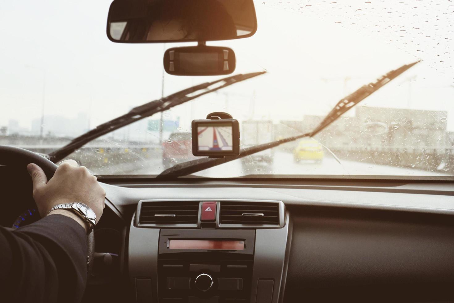 Business man is driving a car in raining day with moving wiper blades photo