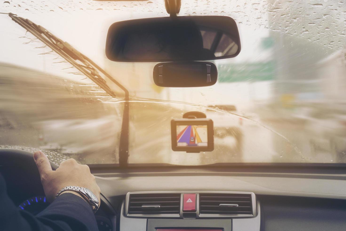 Business man is driving a car in raining day with moving wiper blades photo