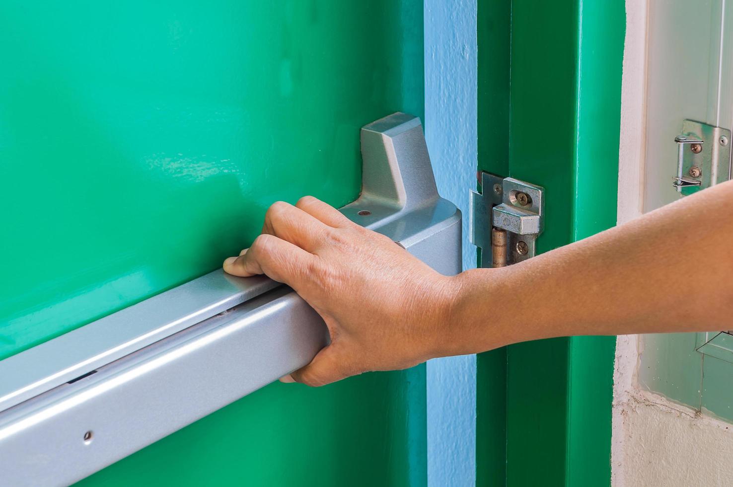 Hand is pushing opening the emergency fire exit door photo