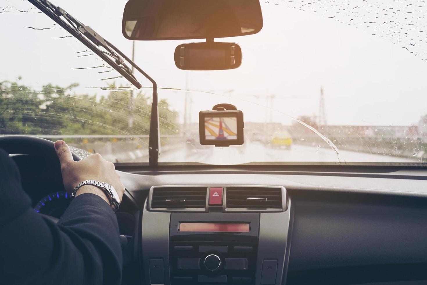 Business man is driving a car in raining day with moving wiper blades photo