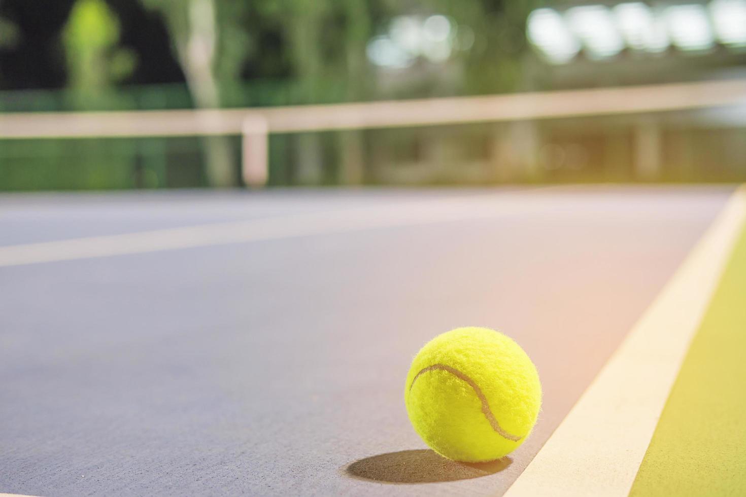 pelota de tenis en la línea de cancha dura foto