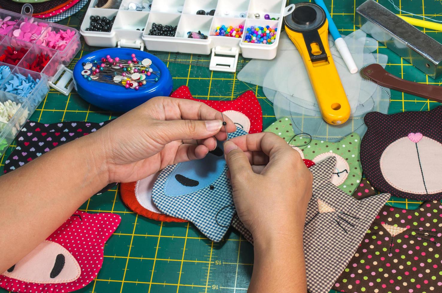 A woman is doing needlework with other embroidery equipment on a table photo