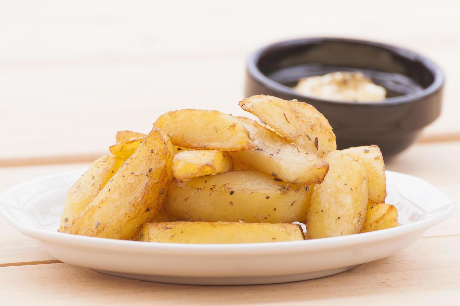 Fried potato with dipped sauce over white wooden table photo