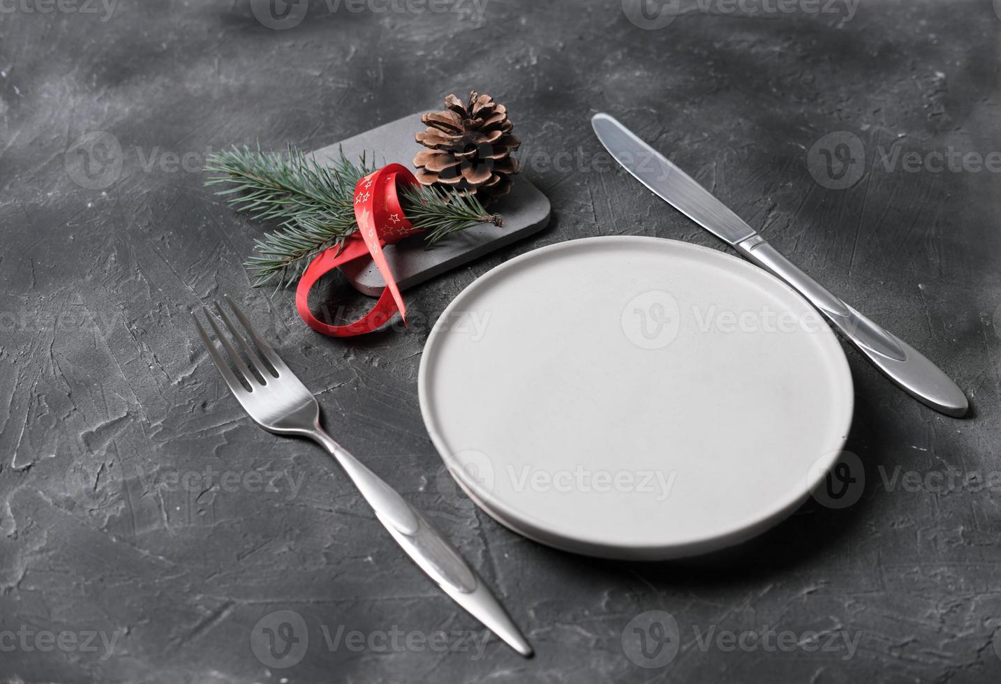 empty plate with tableware and christmas decor on grey table. copy space. table setting template for new year or christmas menu. restaurant menu mock up. top view photo