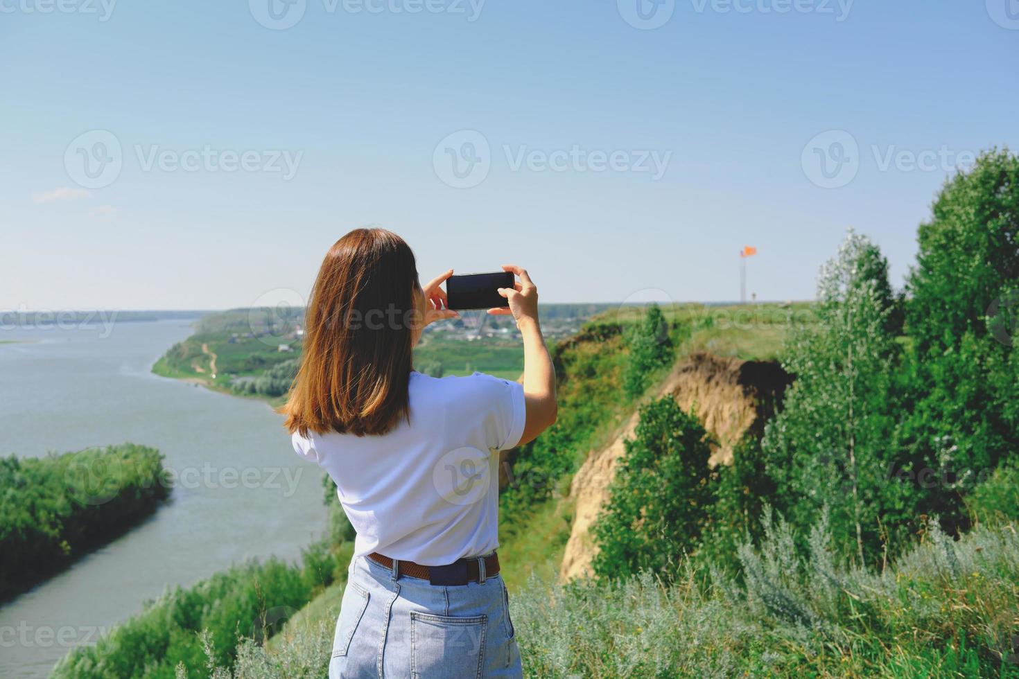 beautiful woman taking a shot of a landscape photo