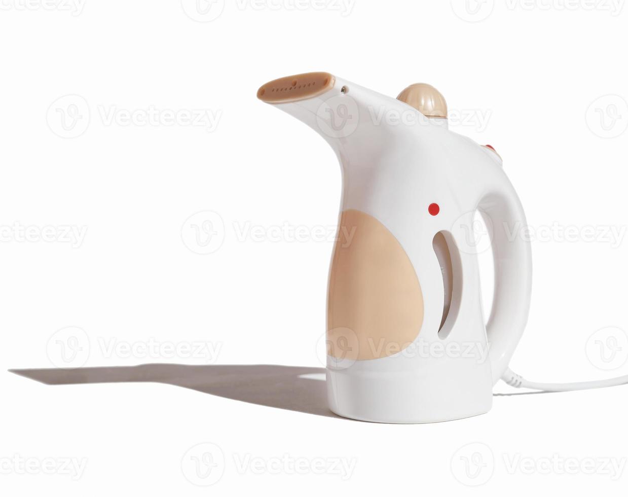compact electric garment steamer on white background. fabric steamer isolated with shadow. housekeeping routine tools. photo