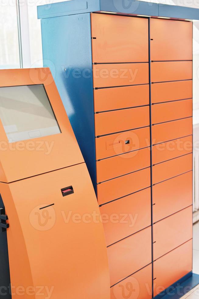 self service post terminal. contactless delivery. automatic shipping machine. mailing service, orange lockers, vertical size photo
