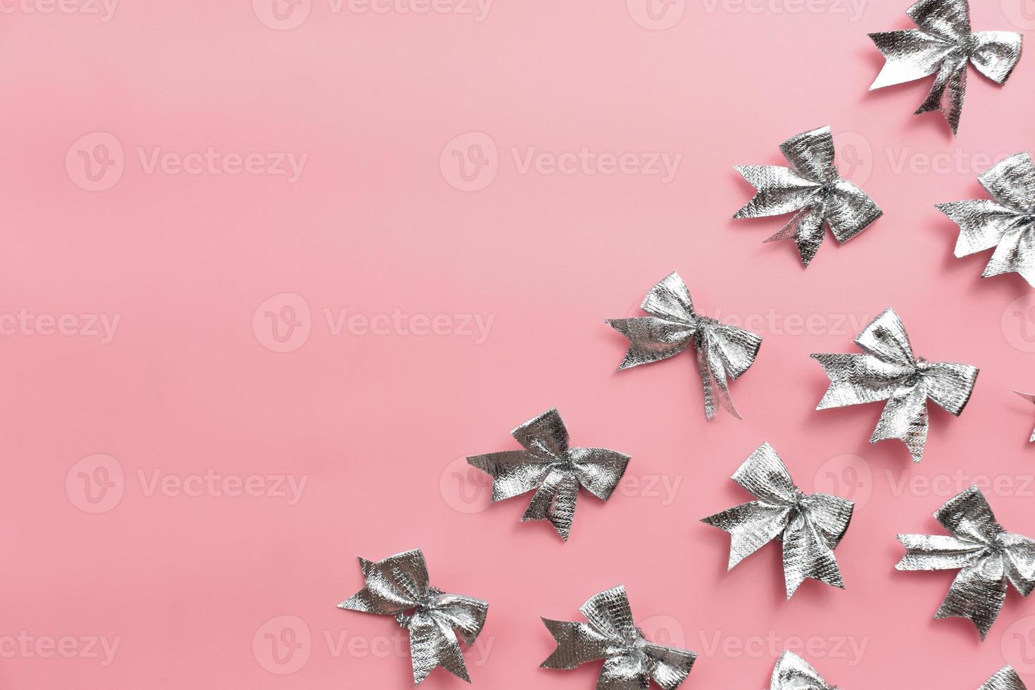 silver ribbon bows on pink background. festive template photo