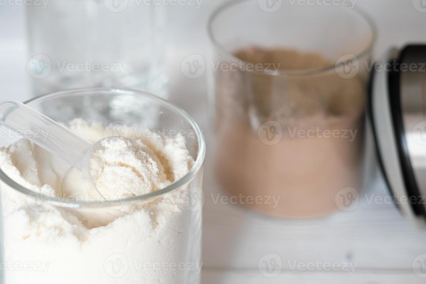 close up view of whey protein in jars with protein powder, chocolate and vanilla flavored supplement for healty joints and face beauty. photo