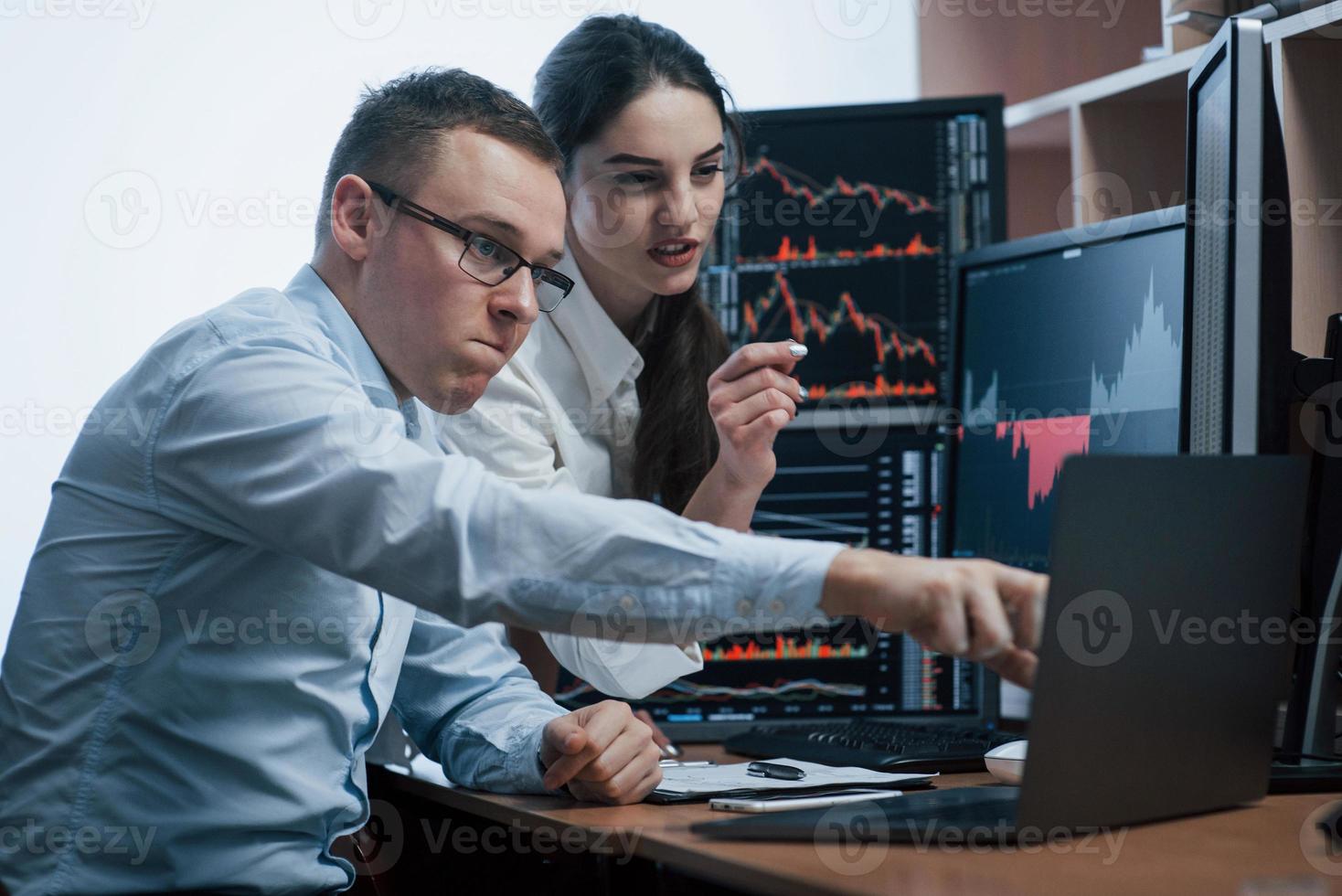 It was been our chance. Team of stockbrokers are having a conversation in a office with multiple display screens photo