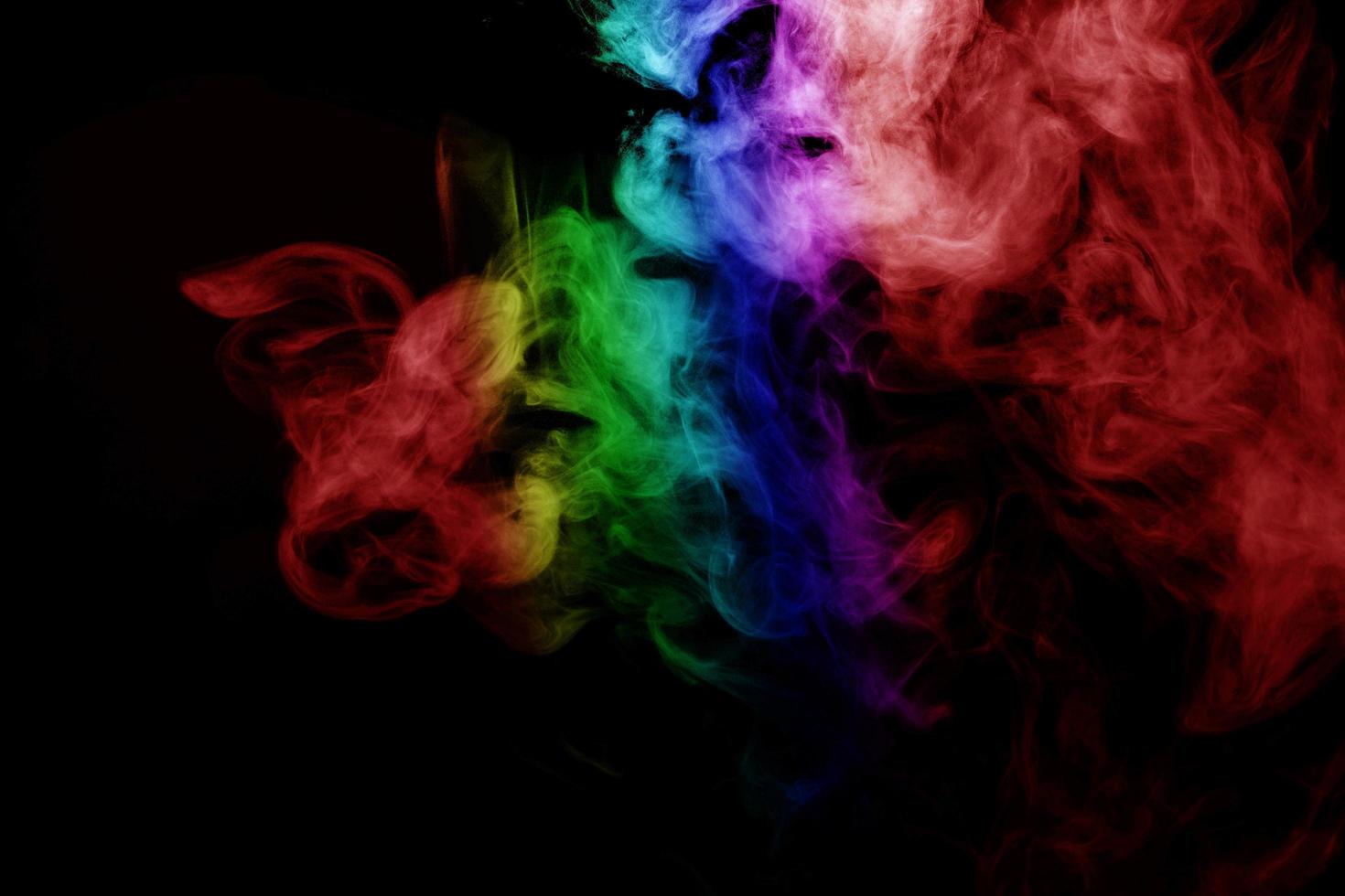 humo abstracto aislado sobre fondo negro, polvo de arco iris foto