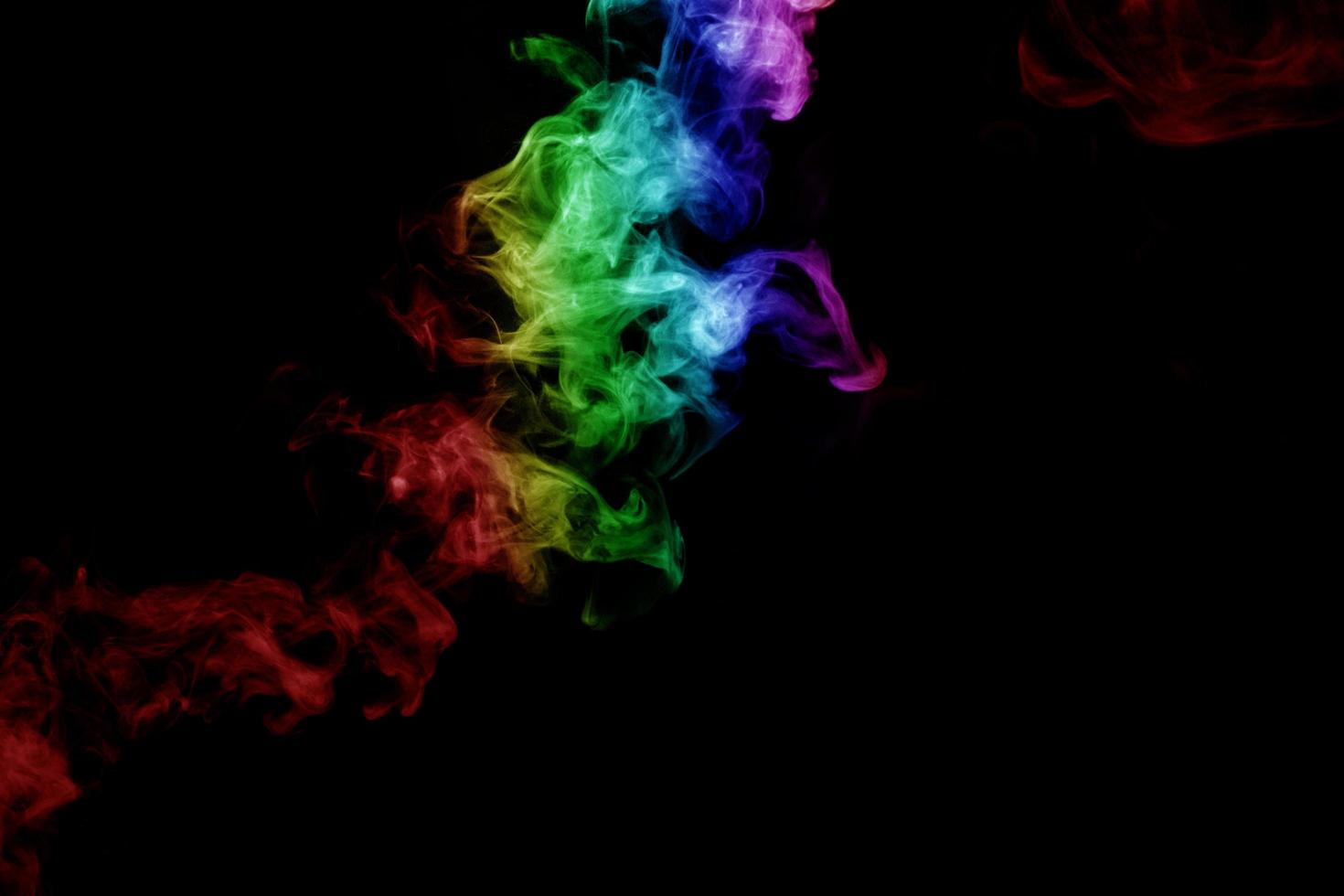 humo abstracto aislado sobre fondo negro, polvo de arco iris foto