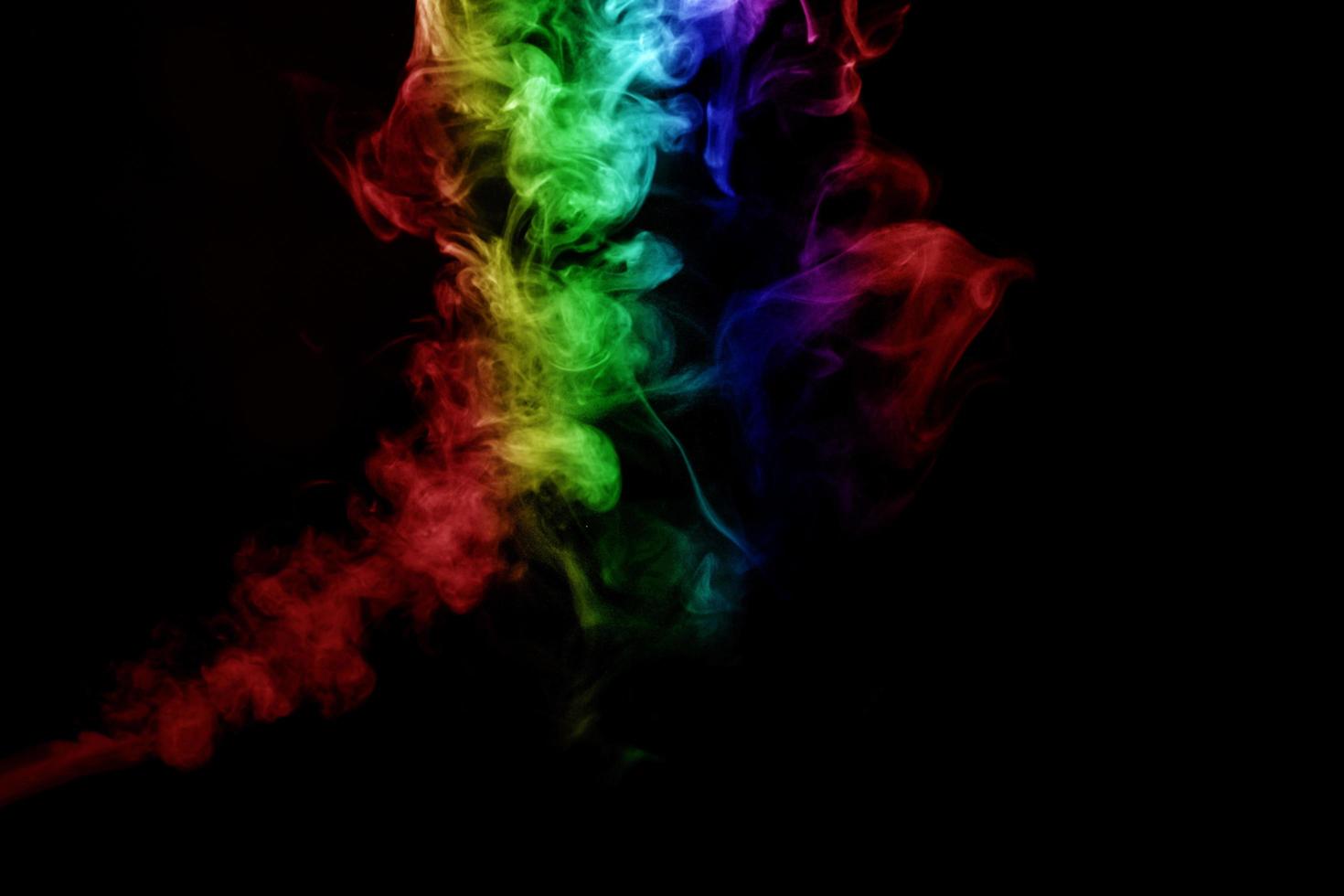 humo abstracto aislado sobre fondo negro, polvo de arco iris foto