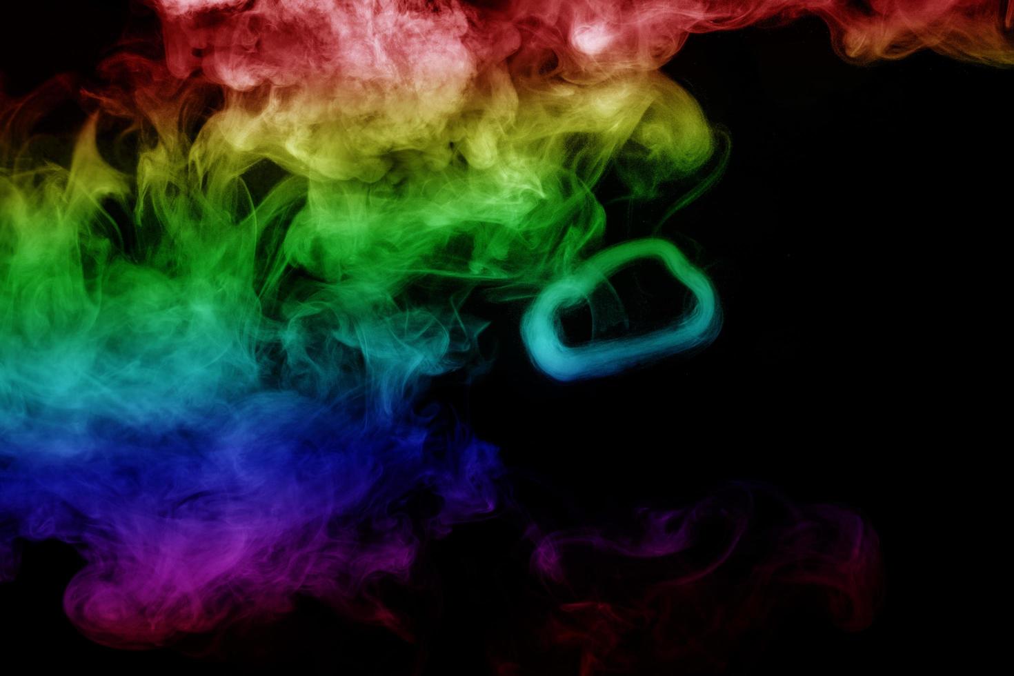 humo abstracto aislado sobre fondo negro, polvo de arco iris foto