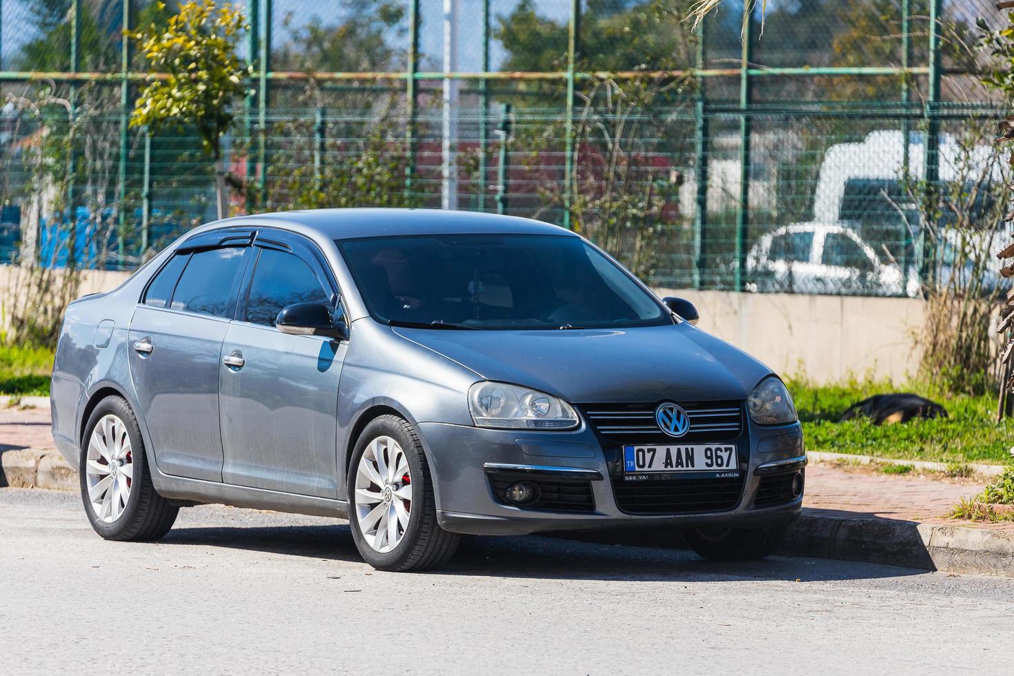 Antalya  Turkey March 04 2022  silver  Volkswagen Jetta is parked  on the street on a warm summer day against the backdrop of a  stadium photo