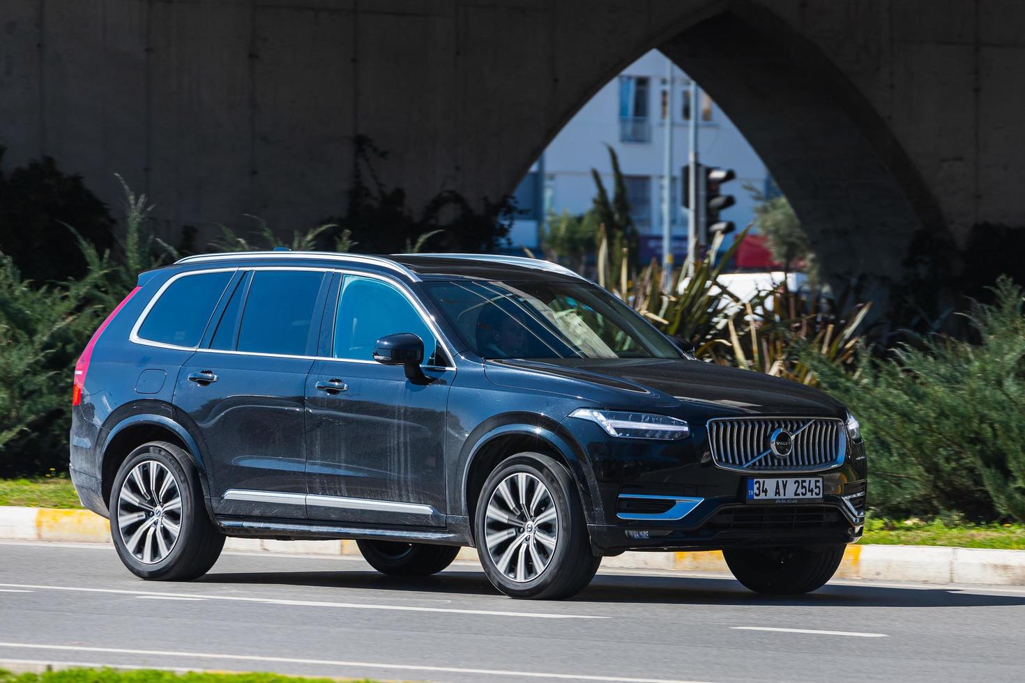 antalya, turquía, 04 de marzo de 2022, el volvo xc90 negro conduce rápido en la calle en un cálido día de verano con el telón de fondo de un puente foto