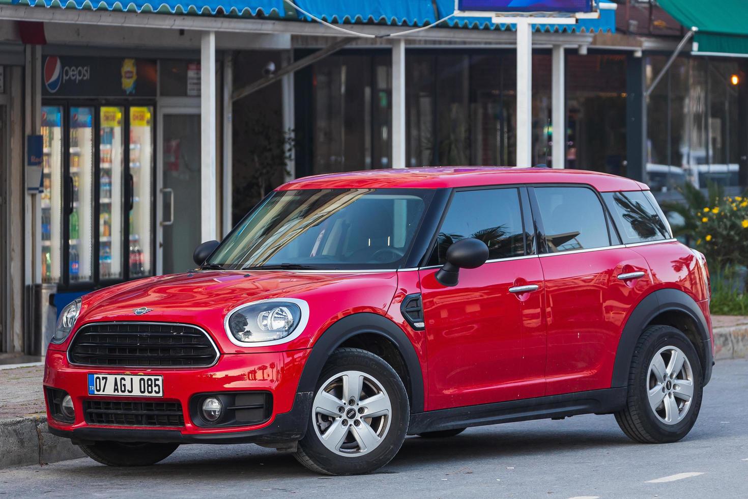 Manavgat  Turkey March 05  , 2022  red Mini Countryman    is parked  on the street on a warm summer day against the backdrop of a buildung, trees photo