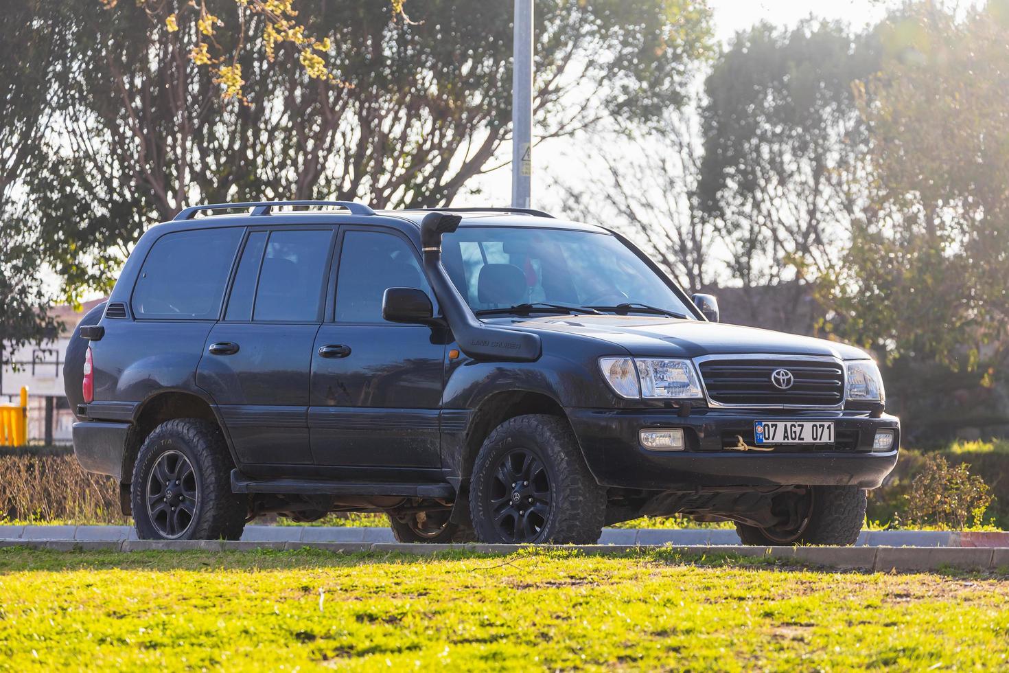 Manavgat  Turkey March 05  , 2022   black  Toyota Land Cruiser  100 is parked  on the street on a warm summer day photo