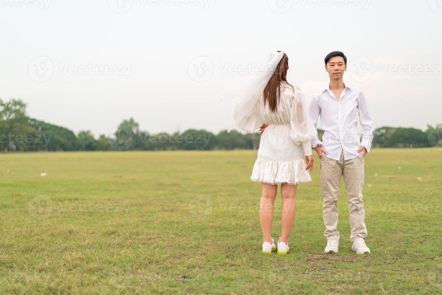 Happy young Asian couple in bride and groom clothing photo