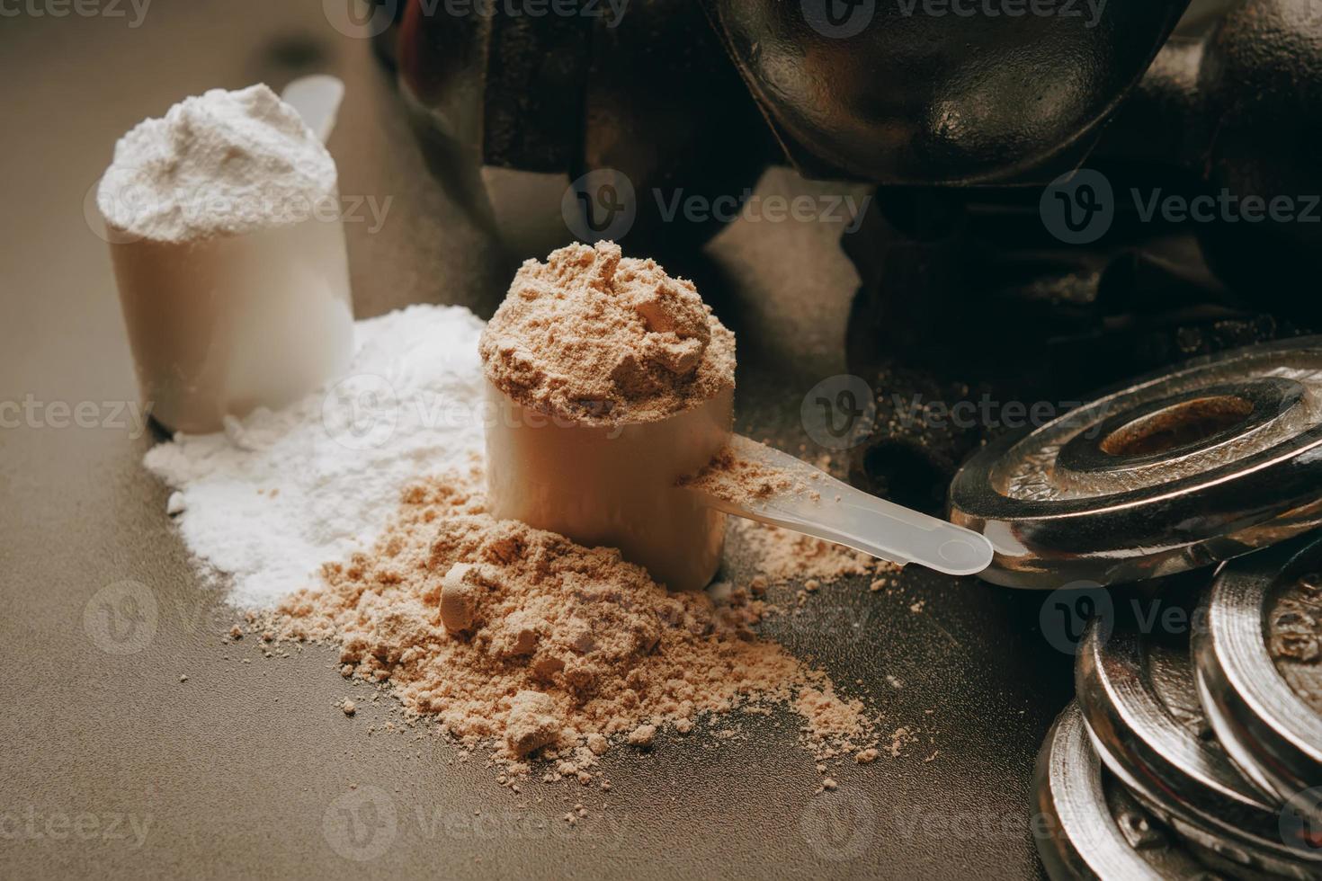 Scoop of protein powder with dumbbell background ,Fitness or healthy lifestyle concept. selective focus photo