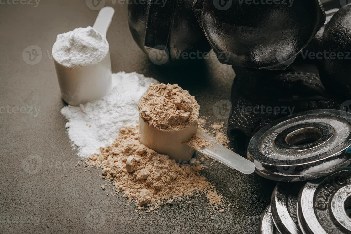 Scoop of protein powder with dumbbell background ,Fitness or healthy lifestyle concept. selective focus photo