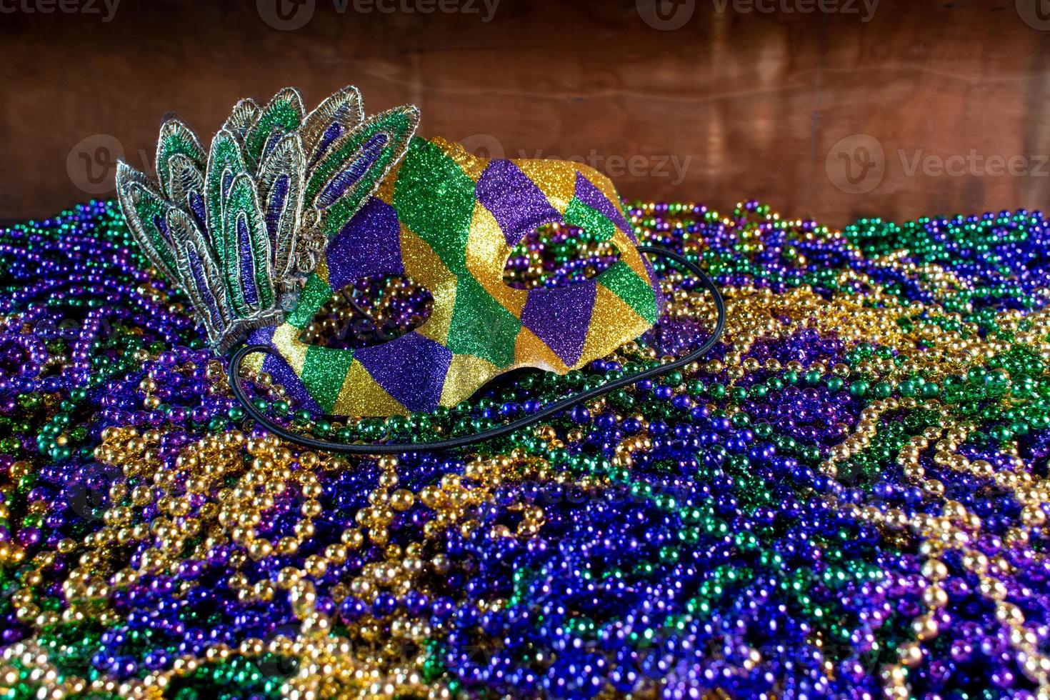 Pile of Mardi Gras beads with colorful carnival mask with copy space photo