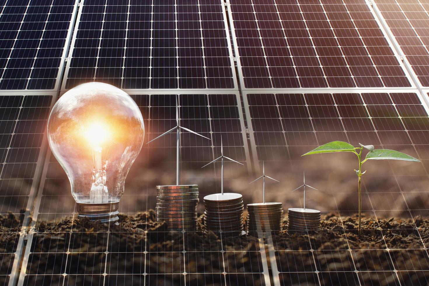 concepto de energía limpia y ahorro de energía en la naturaleza. panel solar con turbina eólica sobre dinero y bombilla foto
