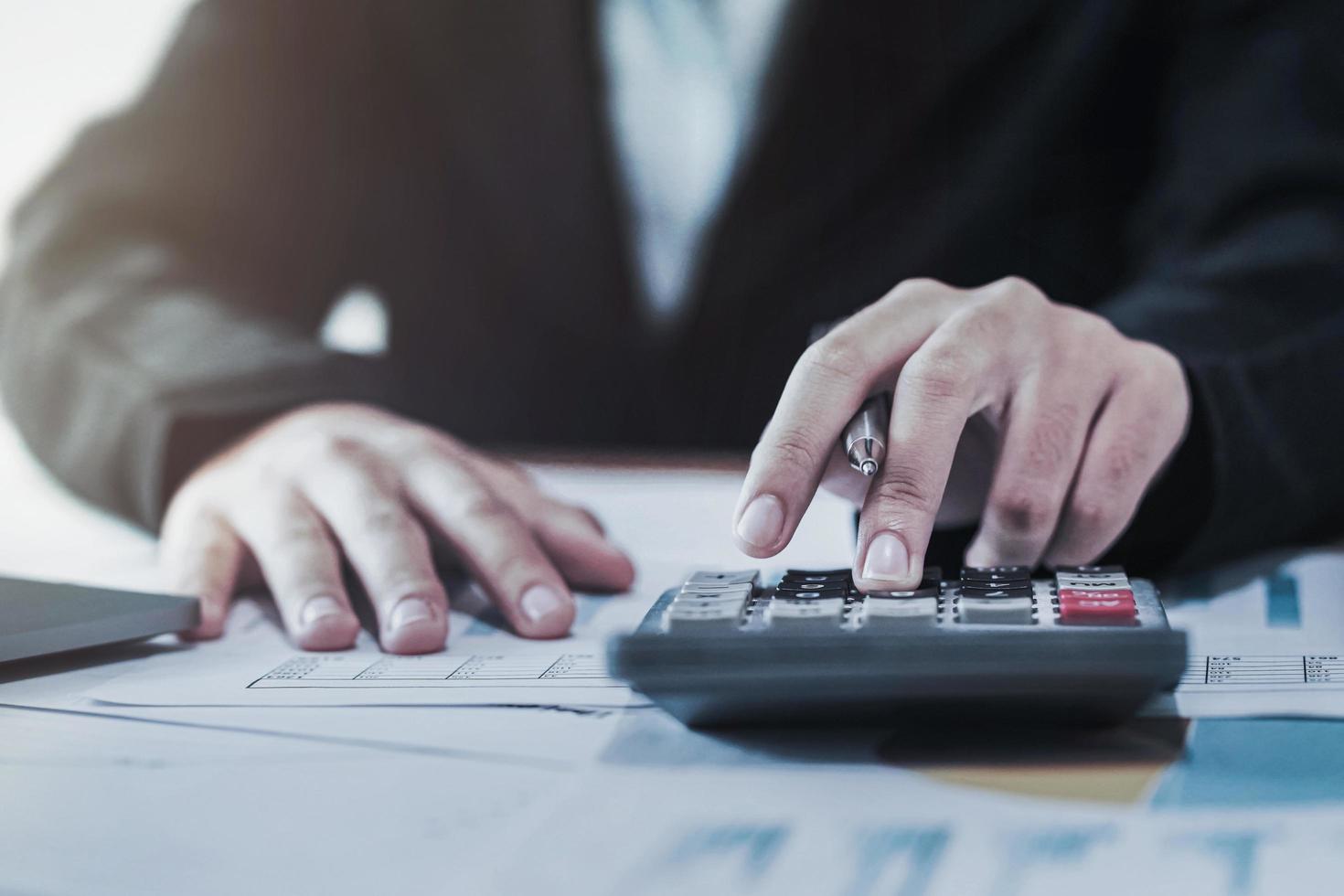 business accounting finance concept. accountant using calculator for calculate  with laptop working in office photo