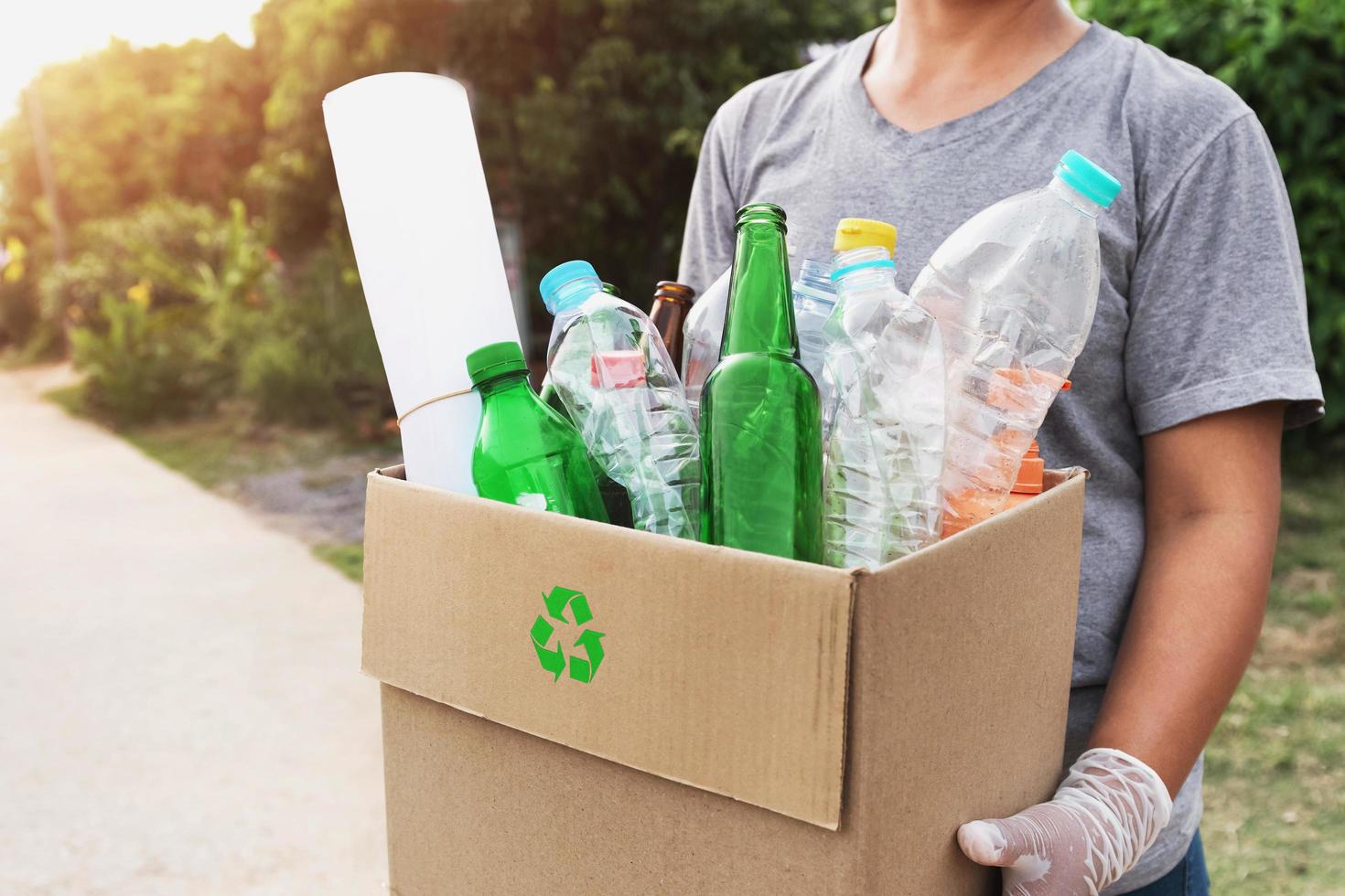 mano de mujer sosteniendo caja de basura para reciclar foto