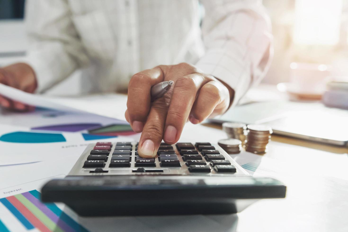 businesswoman working on desk in office and using calculator and laptop with pen for calculate budged money photo