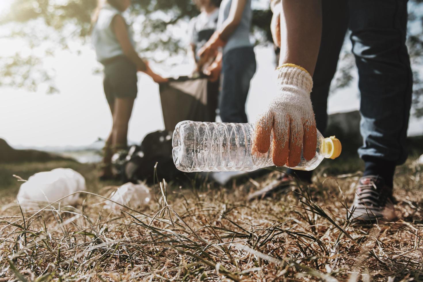 people picking up garbage and putting it in plastic black bag for cleaning photo