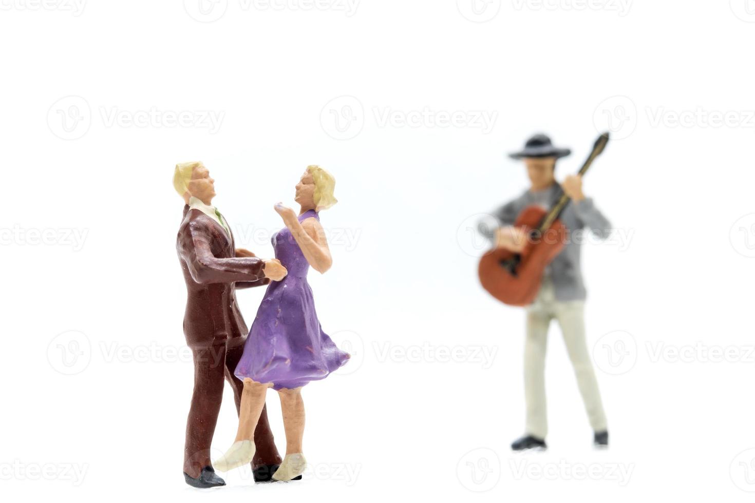 Miniature people Couple dancing with a guitarist playing the guitar photo