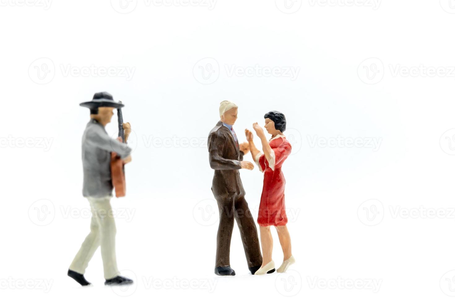 Miniature people Couple dancing with a guitarist playing the guitar photo