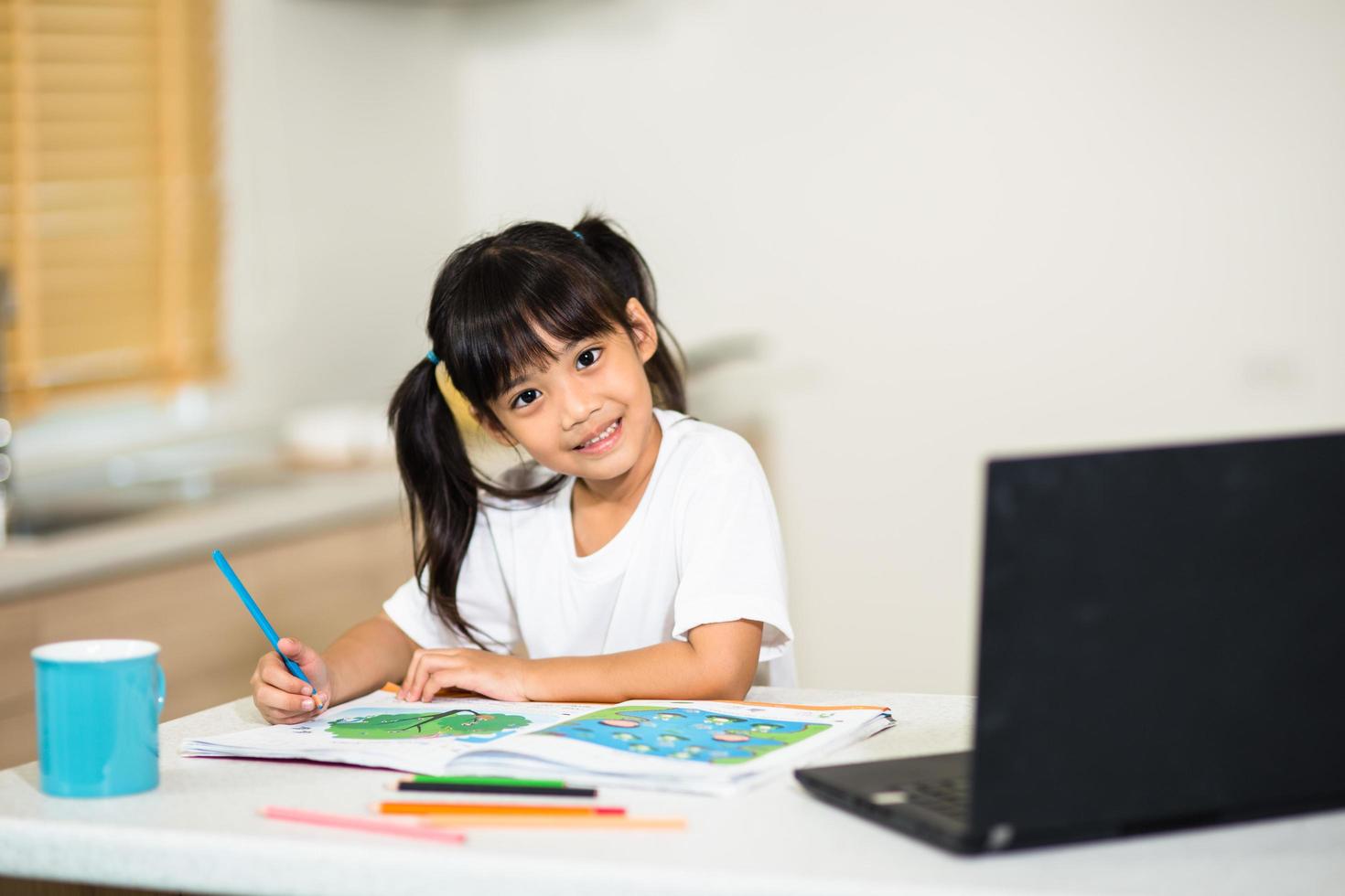 Coronavirus Outbreak. Lockdown and school closures. Schoolgirl watching online education class, happy talking with teacher on the internet at home. COVID-19 pandemic forces children online learning photo