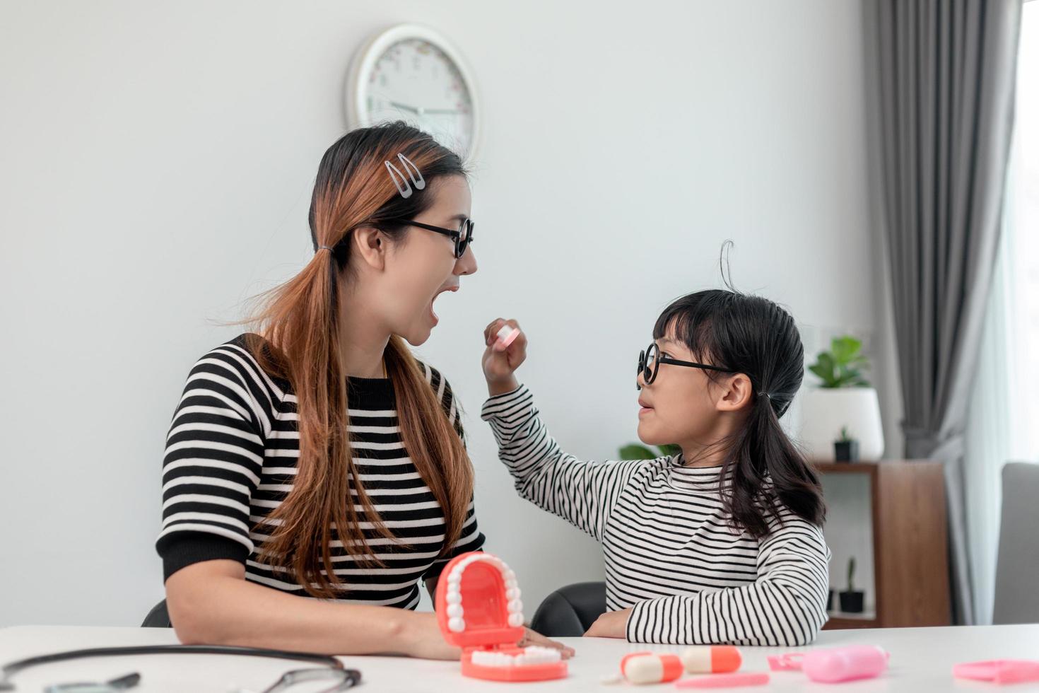 Future doctor checking mother's denture at the home. photo