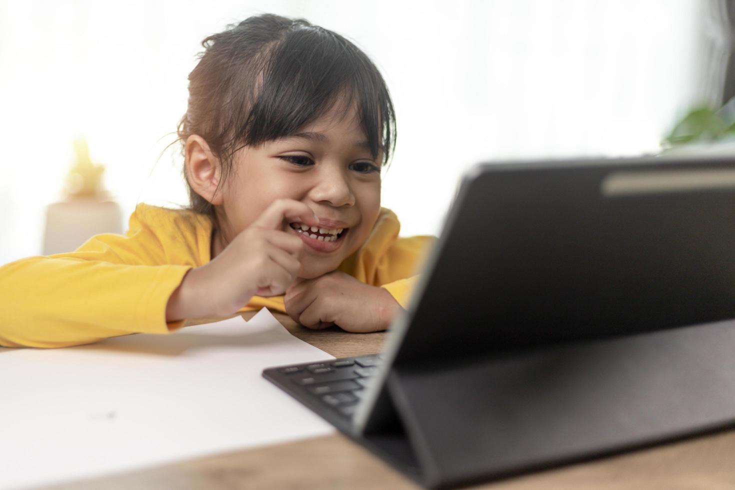 Asian little girl taking class on line and happy for Homeschool Quarantine coranavirus pandemic concept photo