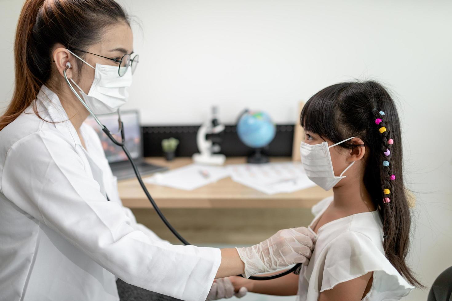 Doctor examining a little girl by stethoscope photo