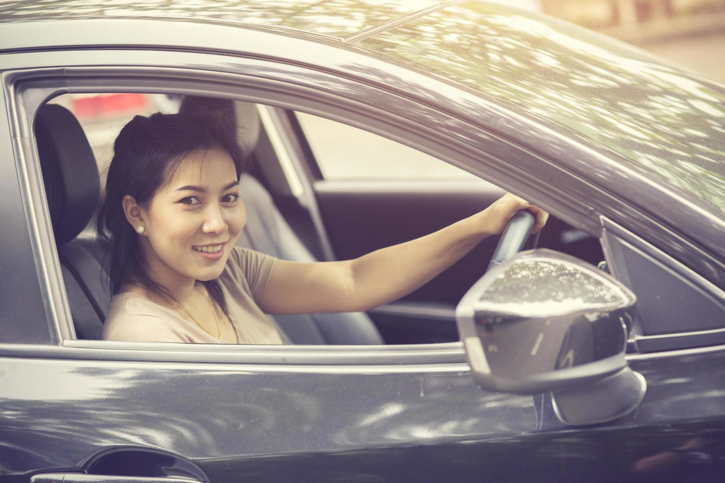 Beautiful girl is smiling while driving a car.Vintage color photo