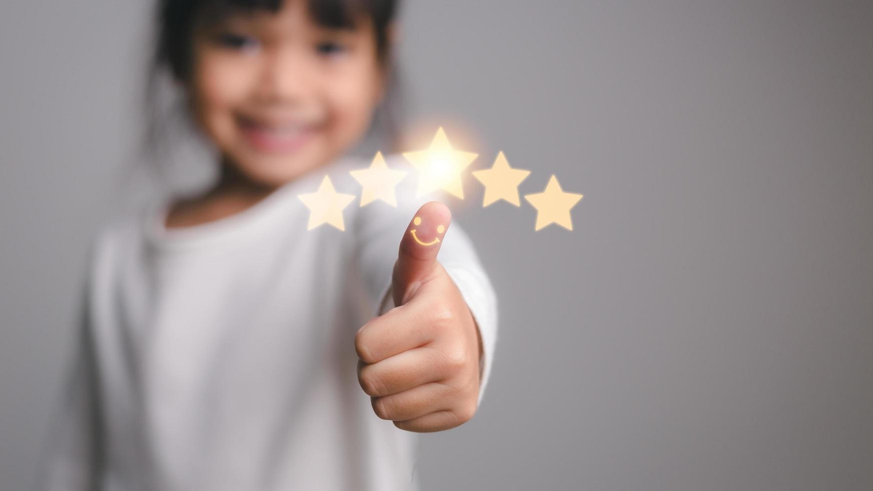 Cute little girl giving thumbs up with 5 stars approved photo