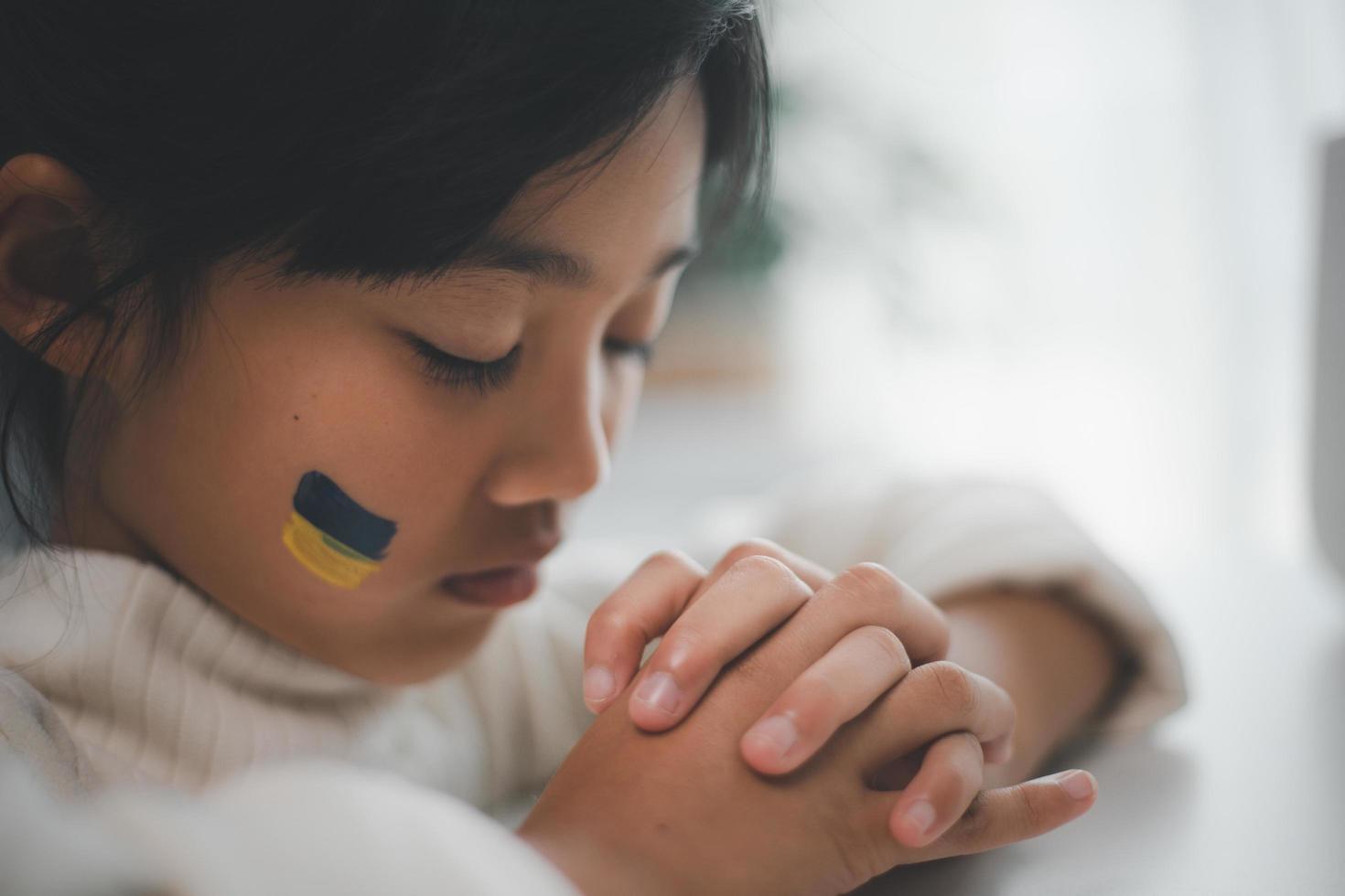 A child with the flag of Ukraine is crying. Sadness longing hope. Children's tears from the war. Evacuation of civilians. Freedom to Ukraine photo